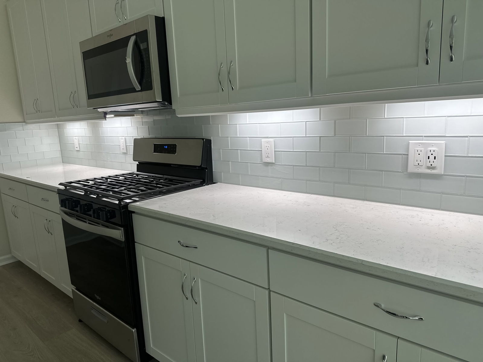 White kitchen with quartz counters and a freshly installed tile backsplash