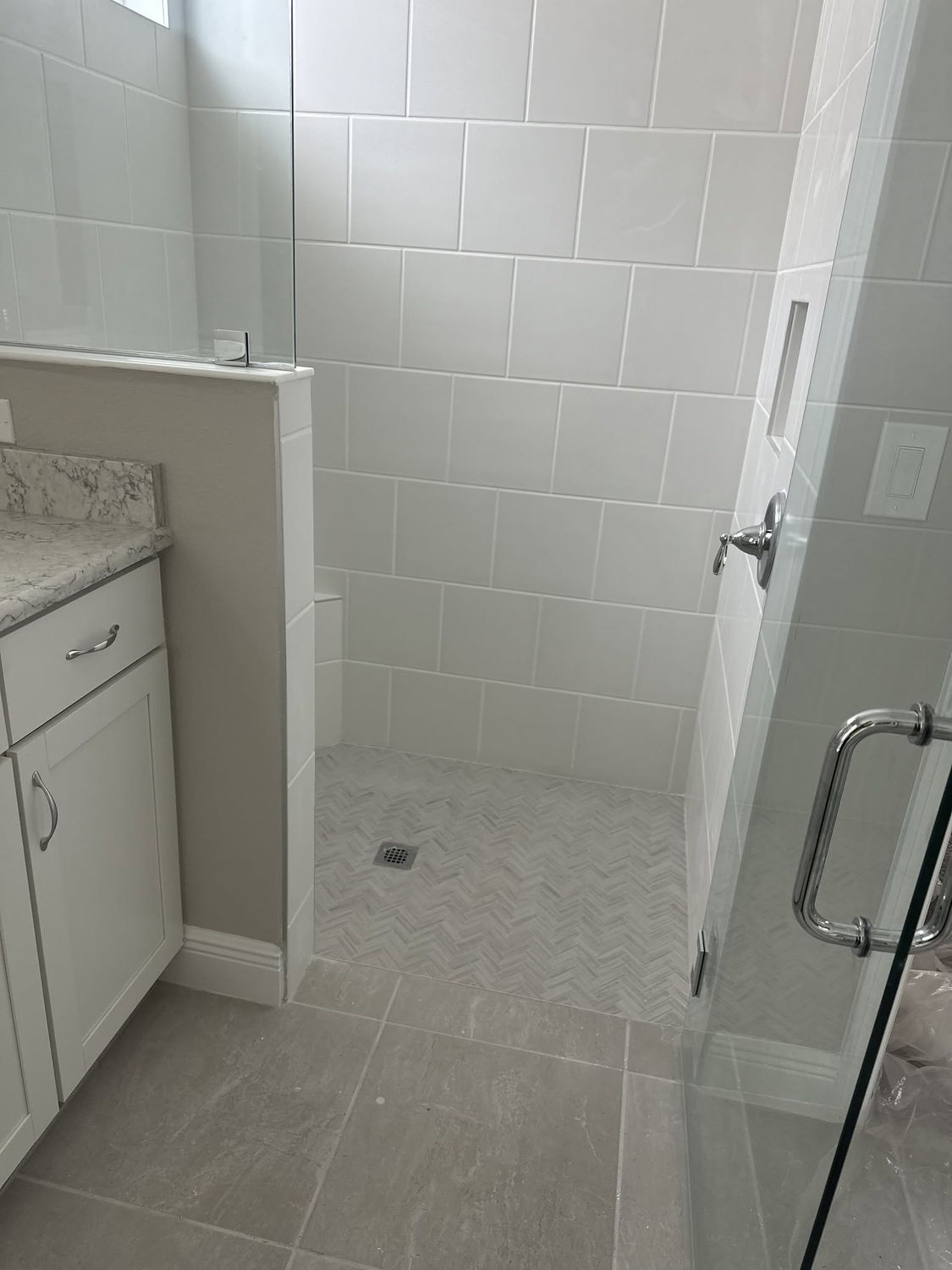 White subway tile shower and tub surround with herringbone floor tile